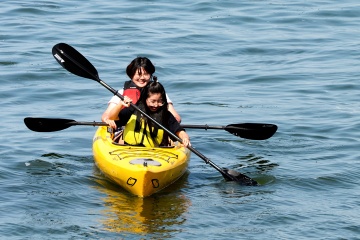 Two smiling people in a yellow kayak.